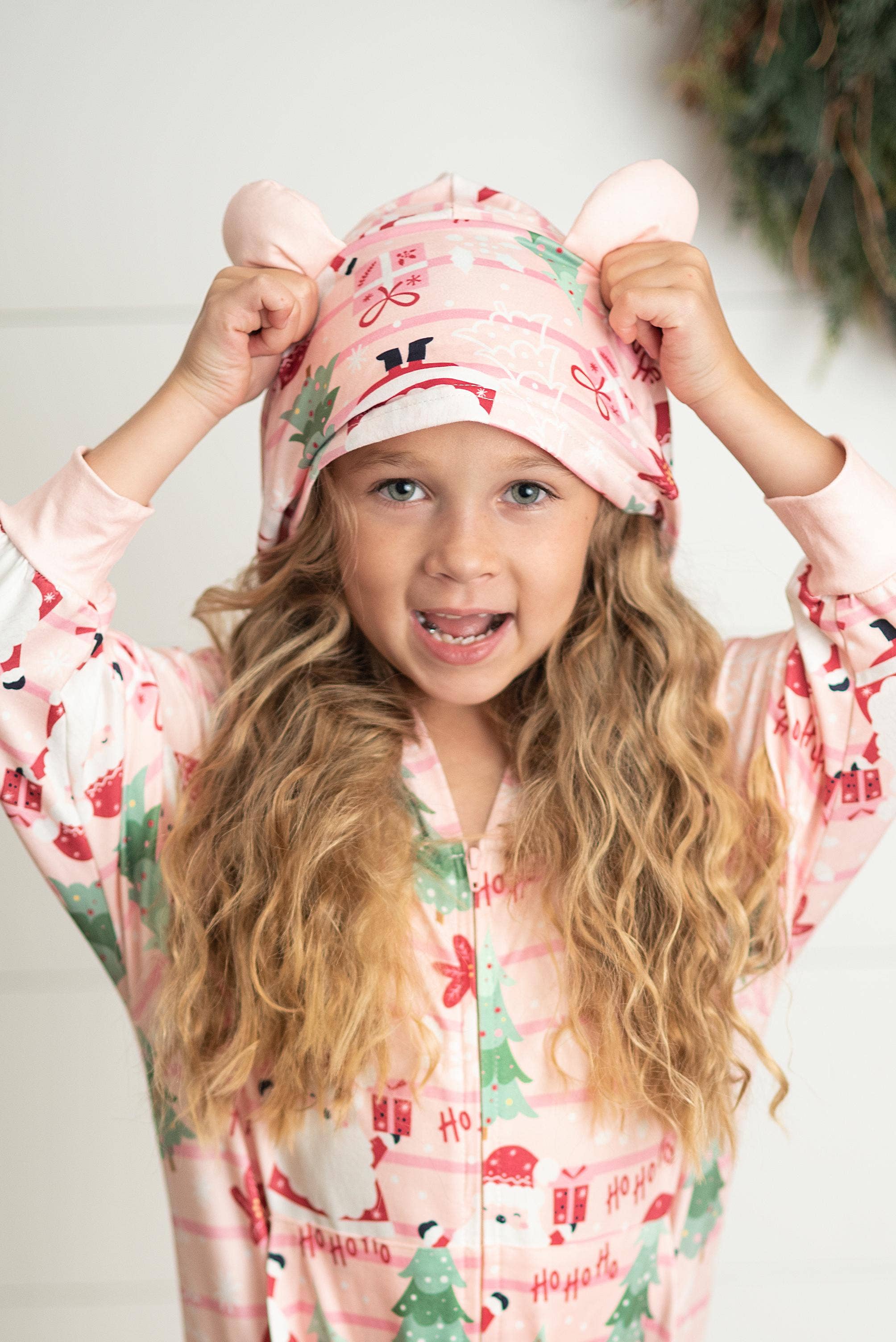 Girls pink and green Christmas Tree Santa print long sleeve onesie with pockets and cute critter ears. Zips up the front. So soft and snuggly for Holiday and Winter playing and lounging! 95% Polyester, 5% Spandex